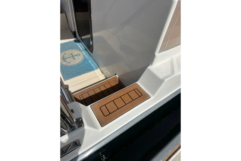 Slide: The Image of 2009 Ranger Tugs R-25 boat steps with anchor-themed mat and wooden accents. - 13