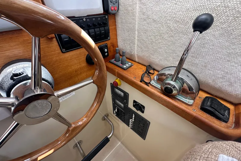 Slide: The Image of 2009 Ranger Tugs R-25 helm with wooden steering wheel and control panel. - 25