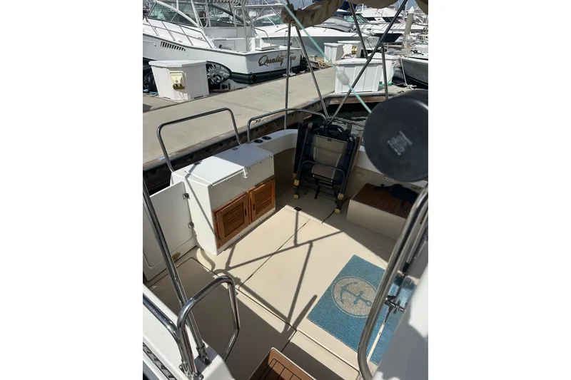 Slide: The Image of 2009 Ranger Tugs R-25 boat deck with storage and seating area at marina. - 14