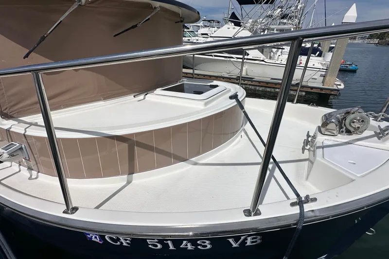 Slide: The Image of 2009 Ranger Tugs R-25 boat docked, featuring a spacious deck and railing. - 11