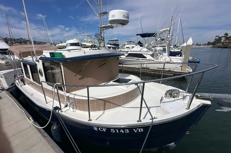 Slide: The Image of 2009 Ranger Tugs R-25 boat docked at marina, surrounded by other vessels. - 8