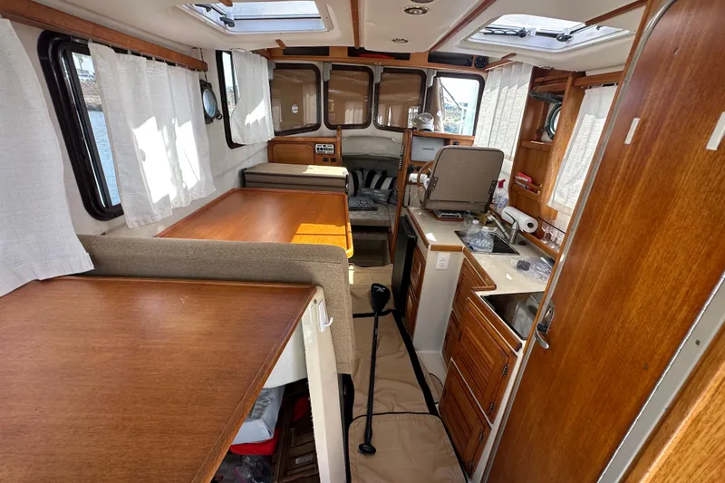 Slide: The Image of Interior of a 2009 Ranger Tugs R-25 boat with wood finishes and compact kitchen. - 18