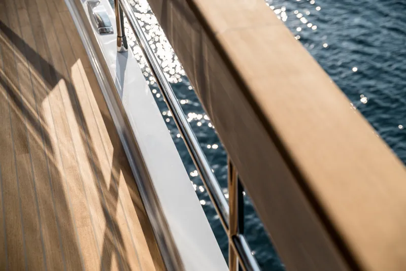 Slide: The Image of Deck view of 2027 Sirena 78 yacht with wooden railing and ocean backdrop. - 19