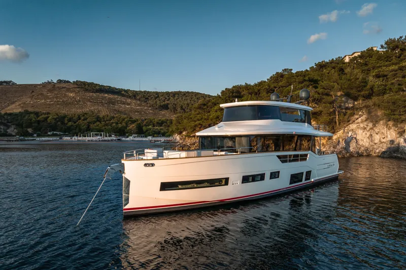 Slide: The Image of Luxurious 2027 Sirena 78 yacht anchored in scenic coastal waters. - 8