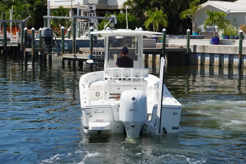 Slide: The Image of 2021 Regulator 24XO boat navigating a marina with a Yamaha outboard engine. - 43