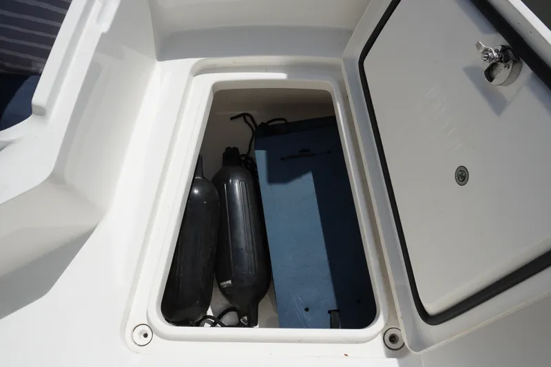 Slide: The Image of Storage compartment on a 2021 Regulator 24XO boat with fenders and a mat. - 19