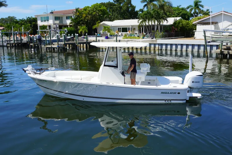 Slide: The Image of 2021 Regulator 24XO boat on calm water near residential docks. - 35