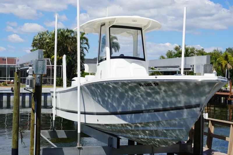 Slide: The Image of 2021 Regulator 24XO boat on lift, docked near waterfront homes. - 33