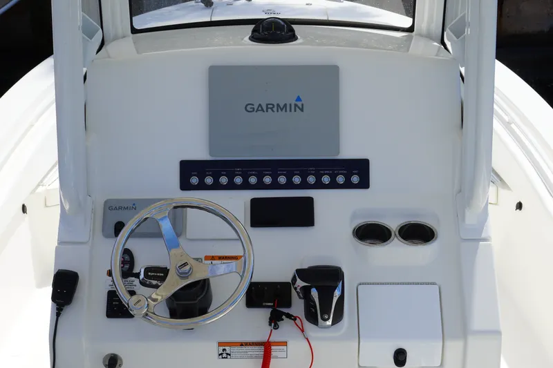 Slide: The Image of 2021 Regulator 24XO boat dashboard with Garmin navigation system and steering wheel. - 17