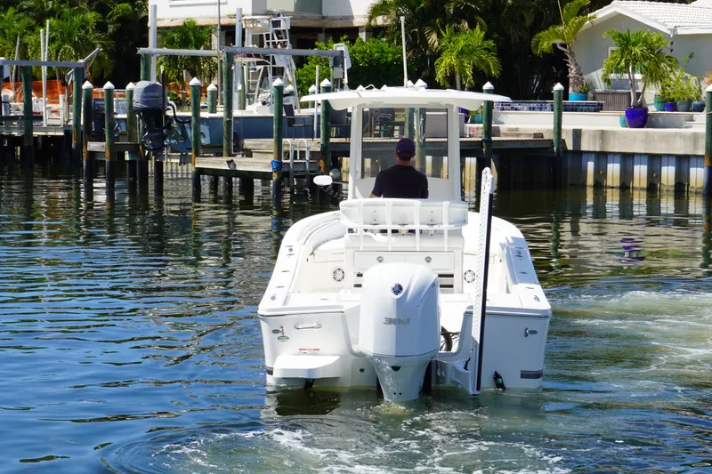 Slide: The Image of 2021 Regulator 24XO boat navigating a marina with lush greenery and docks. - 42