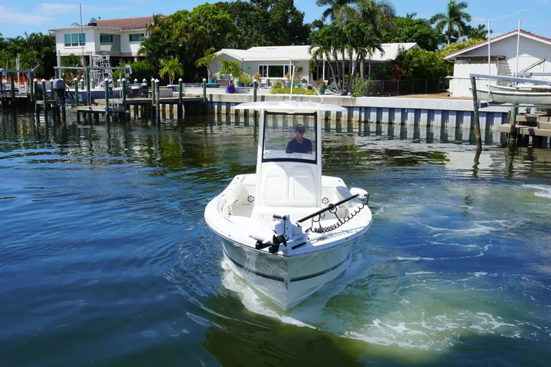 Slide: The Image of 2021 Regulator 24XO boat navigating near waterfront homes and docks. - 38
