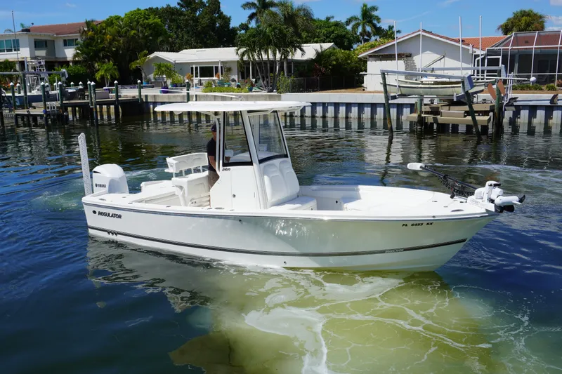 Slide: The Image of 2021 Regulator 24XO boat on calm water near residential docks. - 40