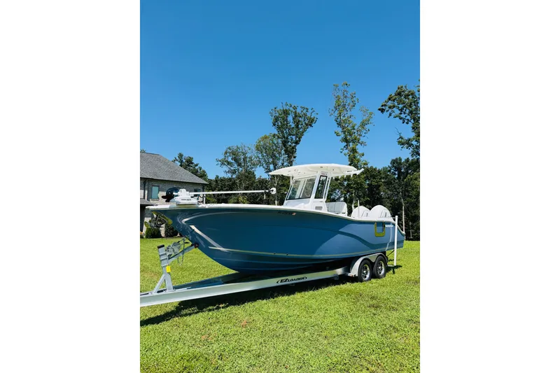 The Image of 2025 Sea Fox 268 Commander boat on trailer, parked on grass under clear blue sky. - 0