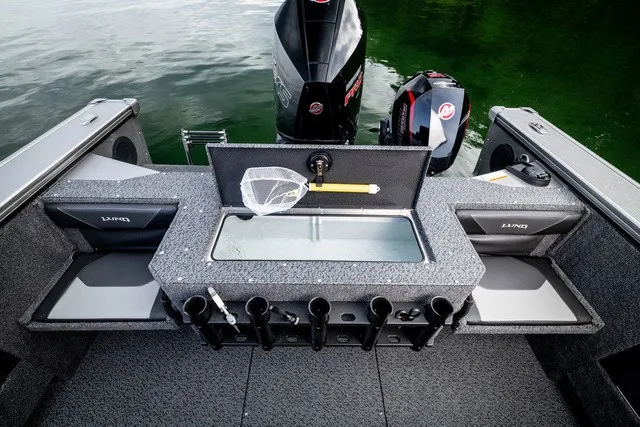 Slide: The Image of The image shows the stern of a Lund 2075 Fisherman boat with rod holders and a motor. - 14