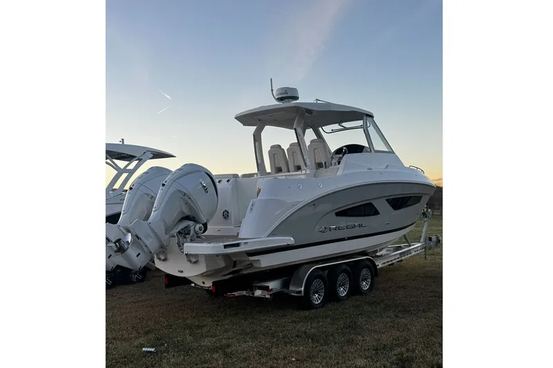 Slide: The Image of 2024 Regal 33 SAV boat on trailer at sunset, showcasing sleek design and powerful engines. - 11