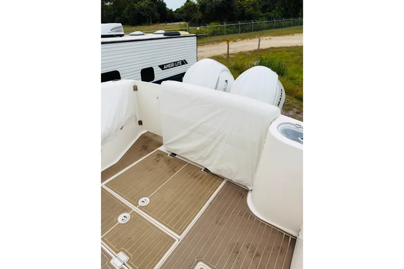 Slide: The Image of 2024 Regal 33 SAV boat deck with covered seating and outboard engines. - 23