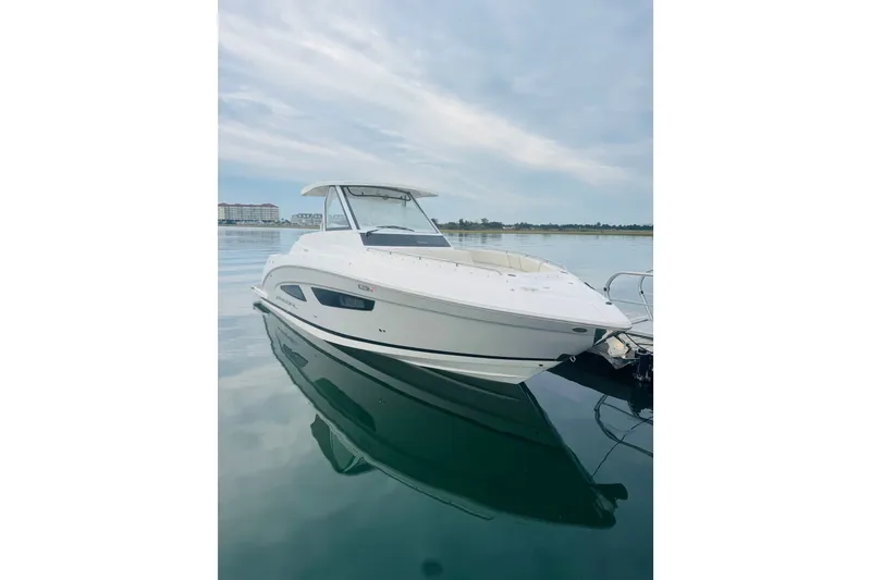 The Image of 2024 Regal 33 SAV boat docked on calm water under a cloudy sky. - 13