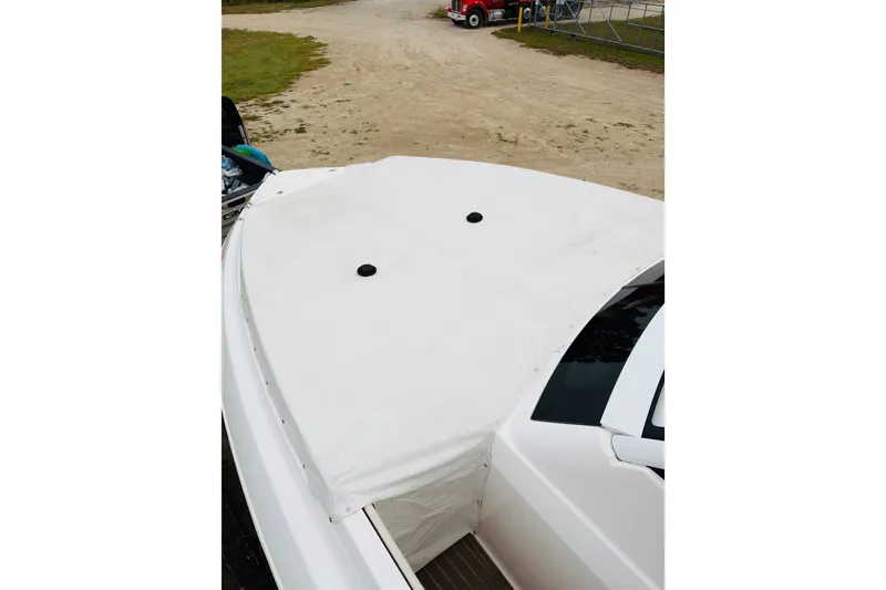 Slide: The Image of 2024 Regal 33 SAV boat with white cover, parked on sandy ground. - 26