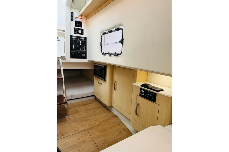 Slide: The Image of 2024 Regal 33 SAV interior cabin with wood flooring, cabinetry, and control panel. - 19