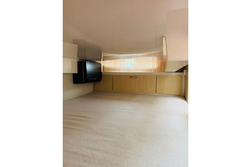 Slide: The Image of 2024 Regal 33 SAV interior cabin with TV, storage, and window. - 16