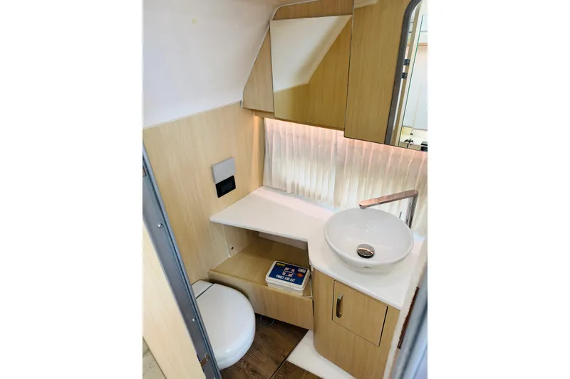 Slide: The Image of 2024 Regal 33 SAV bathroom with modern sink, wooden cabinetry, and ambient lighting. - 13