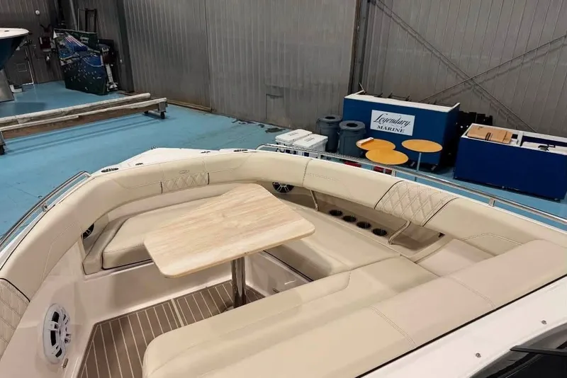 Slide: The Image of 2024 Regal 33 SAV boat interior with beige seating and wooden table in a showroom. - 2