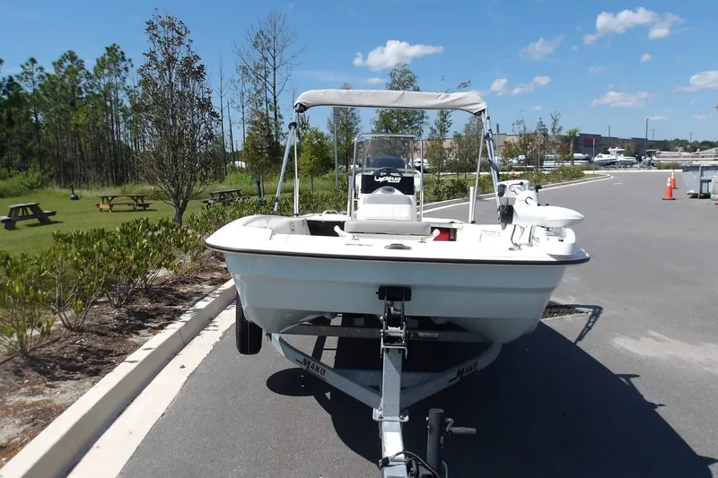 Slide: The Image of 2024 Mako Pro Skiff 17 CC boat on trailer, parked outdoors under clear sky. - 5