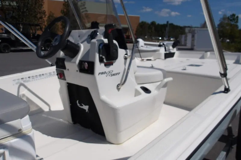 Slide: The Image of 2024 Mako Pro Skiff 17 CC boat interior with steering console and seating. - 2