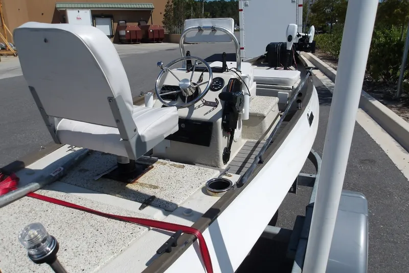 Slide: The Image of 2004 Gheenoe Classic 15 boat with steering console and seating, parked on a trailer. - 2