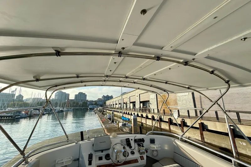 Slide: The Image of 2001 Mainship 390 Trawler docked at marina, view from helm under canopy. - 27