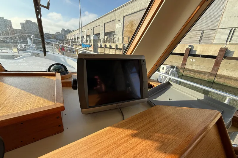 Slide: The Image of 2001 Mainship 390 Trawler helm with GPS display and marina view. - 21