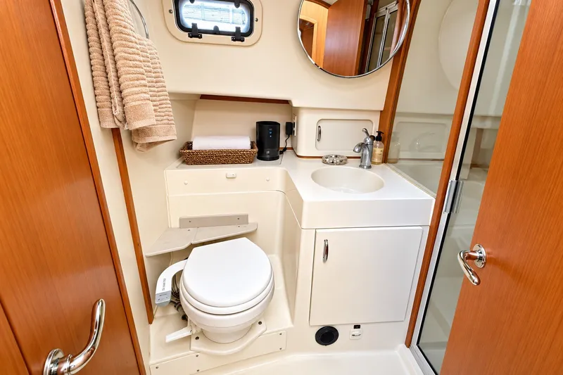 Slide: The Image of Bathroom interior of 2001 Mainship 390 Trawler with toilet, sink, and wooden accents. - 26
