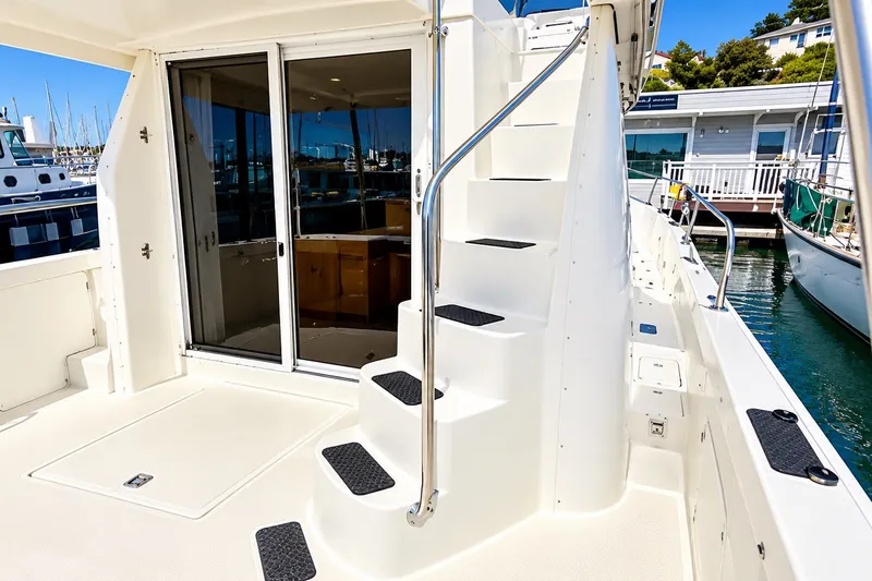 Slide: The Image of 2001 Mainship 390 Trawler with exterior stairs and sliding glass doors at a marina. - 8