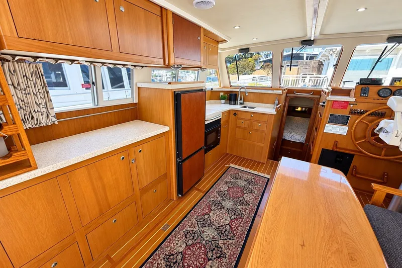 Slide: The Image of Interior of 2001 Mainship 390 Trawler with wood cabinetry and nautical decor. - 18