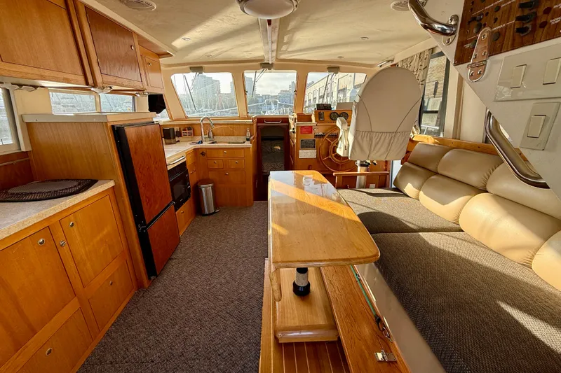 Slide: The Image of Interior of 2001 Mainship 390 Trawler with kitchen, seating, and helm station. - 7