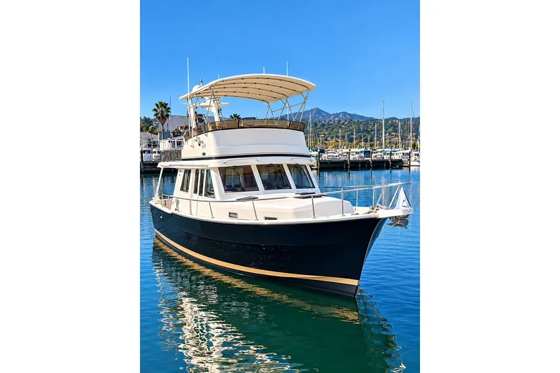 Slide: The Image of 2001 Mainship 390 Trawler docked in a marina under clear blue skies. - 4