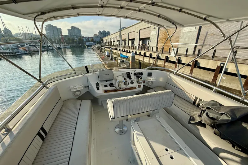 Slide: The Image of 2001 Mainship 390 Trawler helm with marina view, featuring modern navigation equipment. - 26
