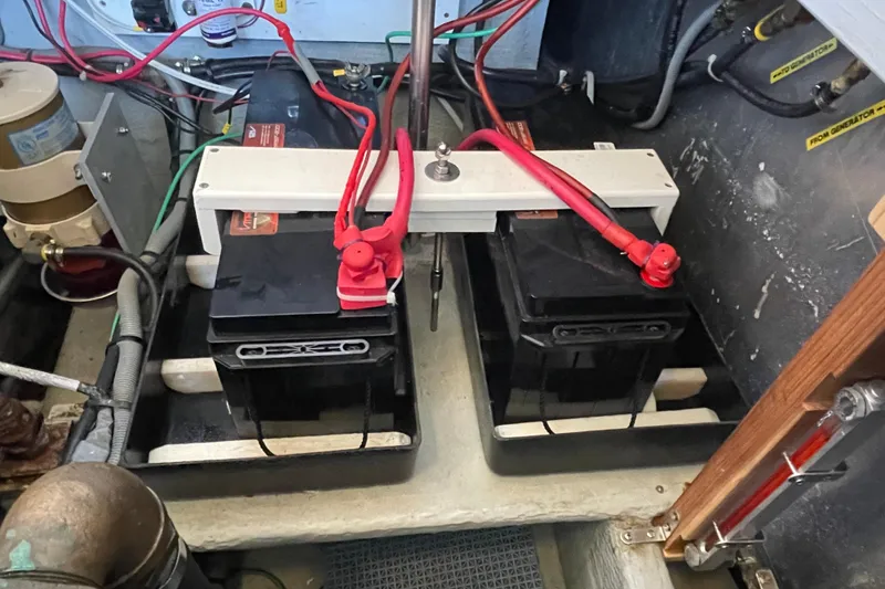 Slide: The Image of Battery compartment of a 2001 Mainship 390 Trawler with connected cables. - 34