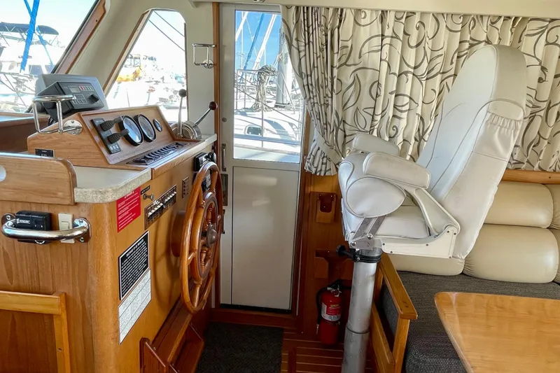 Slide: The Image of 2001 Mainship 390 Trawler helm with wooden wheel, gauges, and captain's chair. - 8