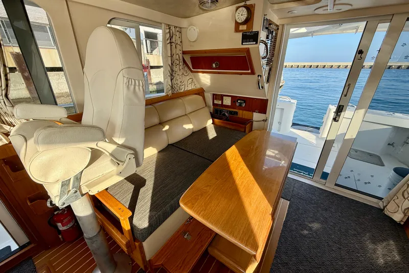 Slide: The Image of Interior of 2001 Mainship 390 Trawler with seating, table, and ocean view. - 12
