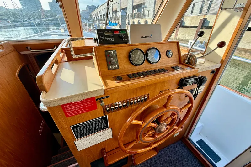 Slide: The Image of 2001 Mainship 390 Trawler helm with wooden wheel, gauges, and Garmin navigation system. - 11