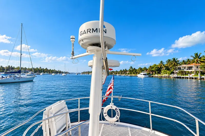 Slide: The Image of 2001 Mainship 390 Trawler on scenic waterway with clear blue sky and palm trees. - 11