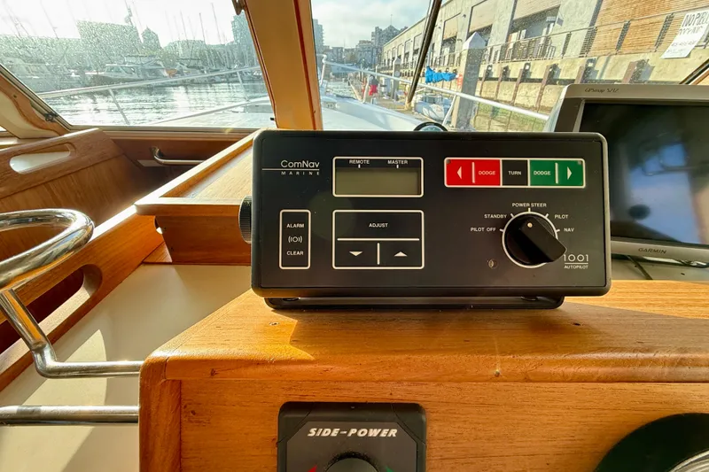 Slide: The Image of 2001 Mainship 390 Trawler helm with ComNav autopilot system and marina view. - 22