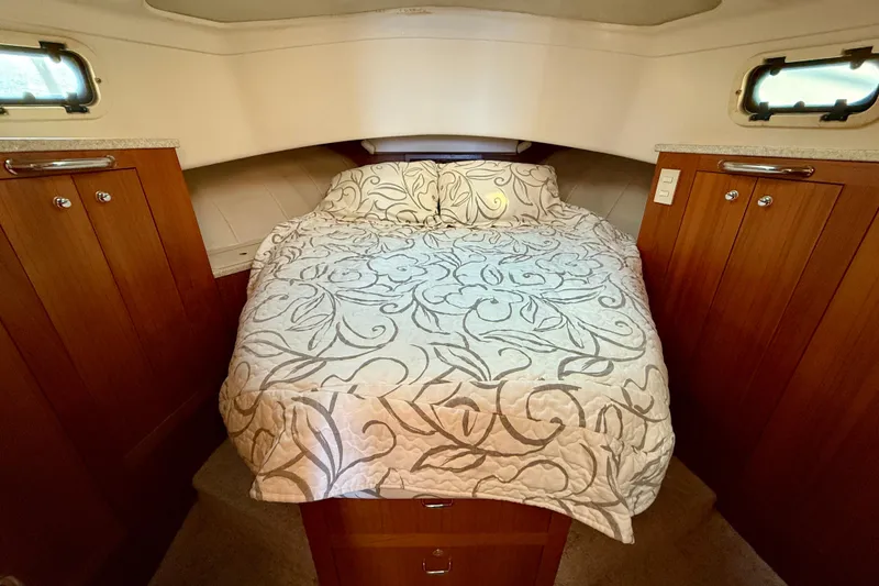 Slide: The Image of Cozy cabin interior of 2001 Mainship 390 Trawler with elegant bedding and wood cabinetry. - 16