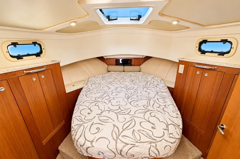 Slide: The Image of Luxurious cabin interior of 2001 Mainship 390 Trawler with elegant bedding and wood cabinetry. - 23