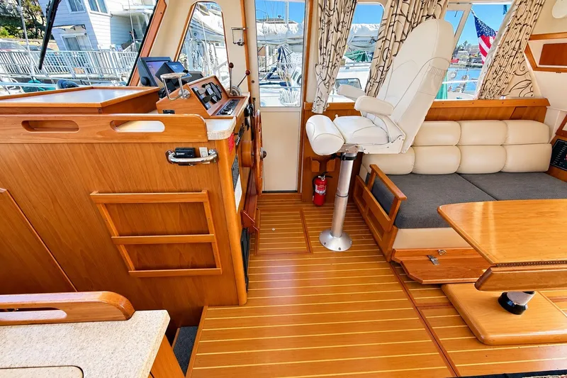 Slide: The Image of Interior of 2001 Mainship 390 Trawler with wooden flooring and helm station. - 15