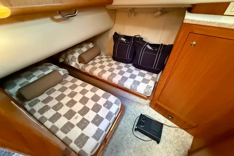 Slide: The Image of Cozy cabin interior of 2001 Mainship 390 Trawler with twin beds and wooden cabinetry. - 23