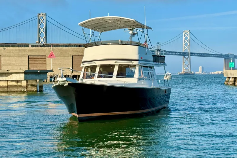 The Image of 2001 Mainship 390 Trawler in harbor, bridge in background, sunny day. - 0