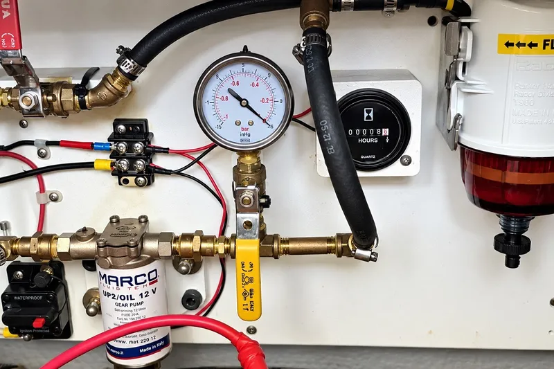 Slide: The Image of Engine room components of a 2001 Mainship 390 Trawler, featuring gauges and wiring. - 35