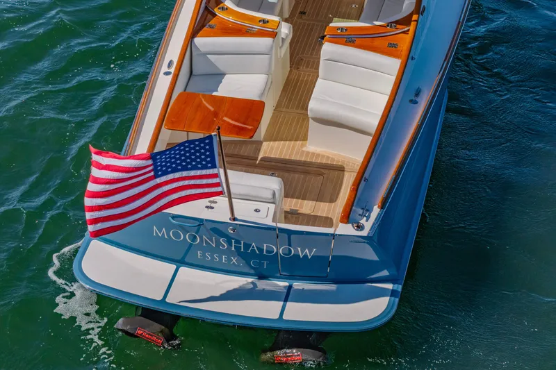 Slide: The Image of Hinckley Picnic Boat 34 MKII, 2021, with American flag, named "Moonshadow," on water. - 5